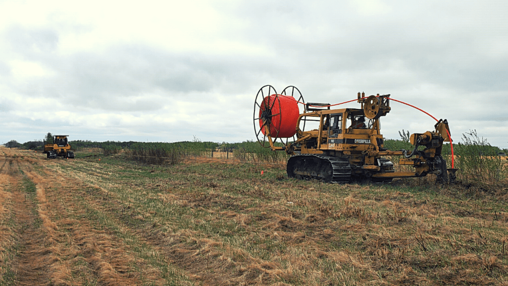 Heavy equipment drilling fiber optic cables for high speed internet in rural Alberta.
