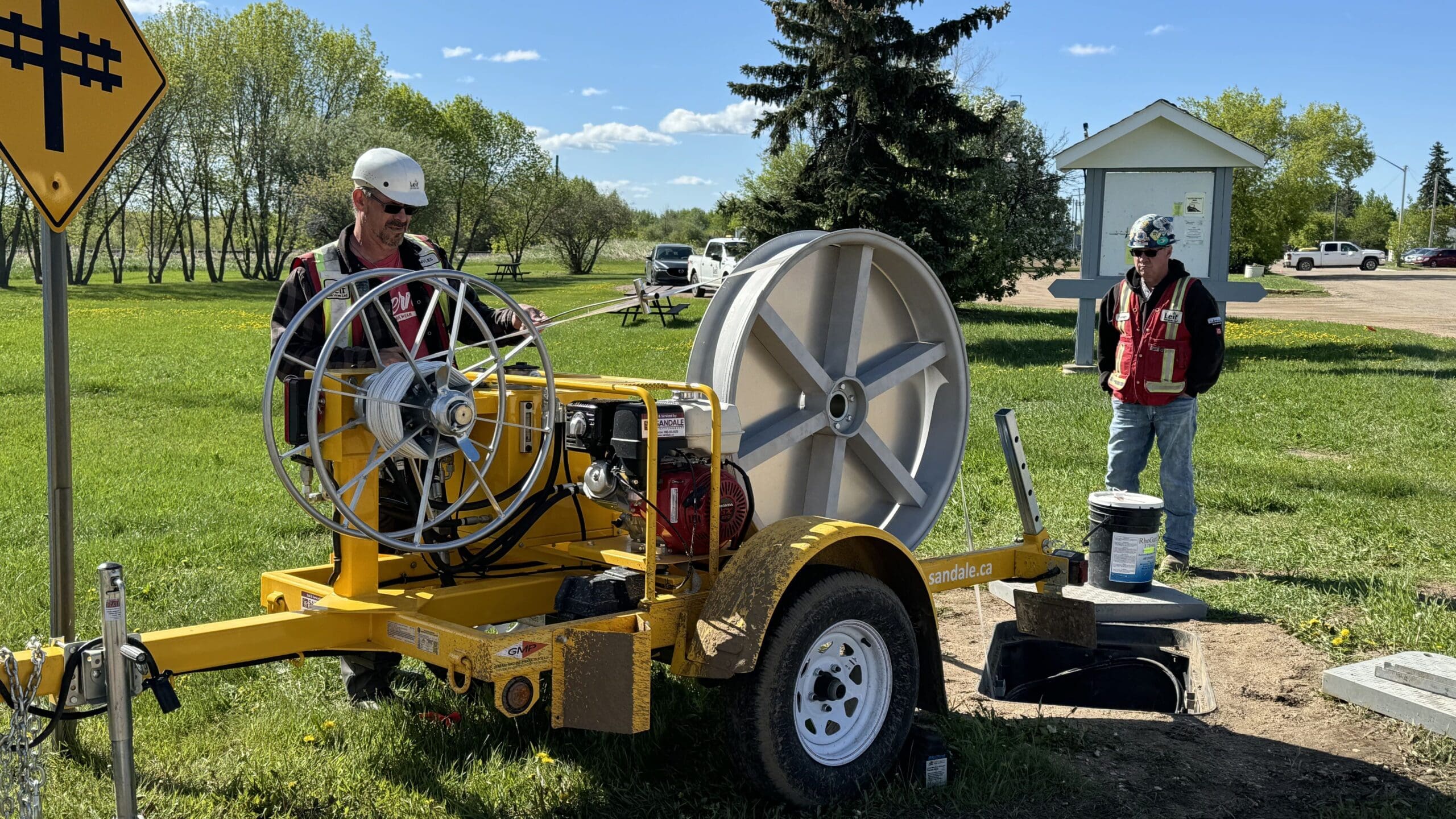 Photo of two construction workers in hard hats and vests with fiber optic machinery building broadband throughout Thorhild.