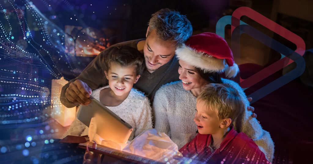 A young family watching as a the son opens a gift.