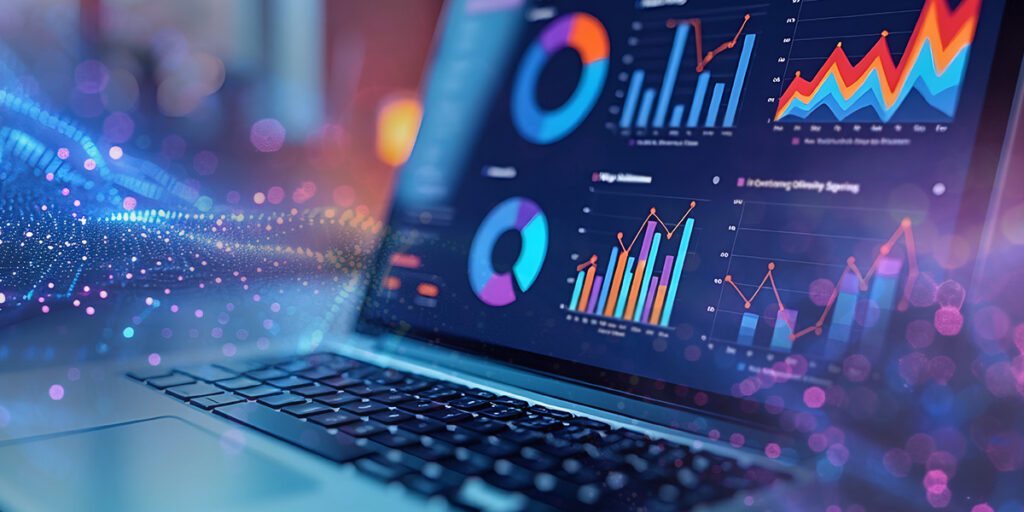 Decorative image of a laptop sitting on a desk displaying graphs on the screen.