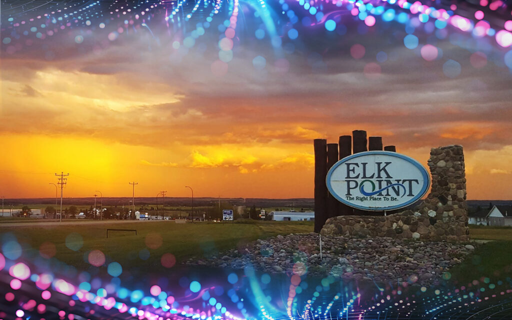Photo of the Elk Point, Alberta town sign at dusk, with a beautiful sunset creating a warm glow.