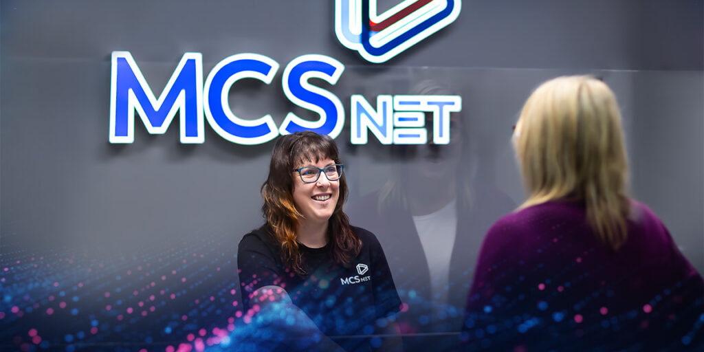 Image of a Customer Service Rep at the front office of MCSnet serving a customer.