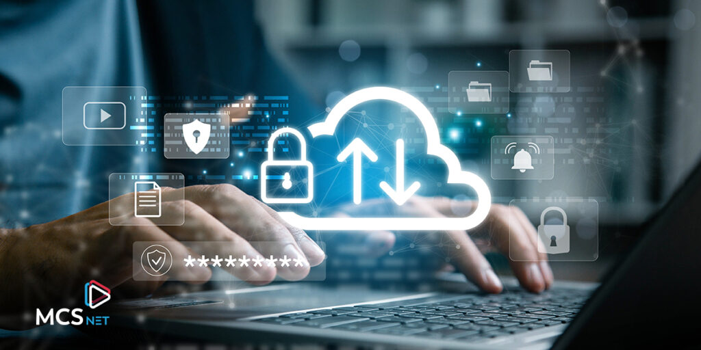 Close-up image of hands typing on a laptop keyboard with a digital graphic overlay with symbols for cloud data, locks, security, etc.