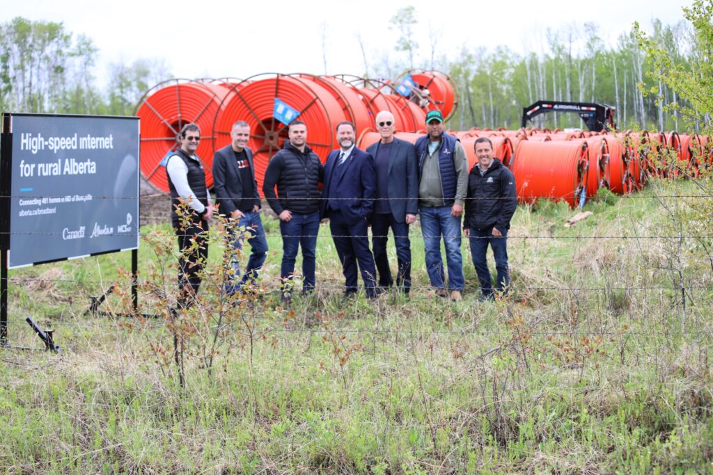 photo of MCSnet representatives with MLA Scott Cyr and MD of Bonnyville council in front of fiber spools