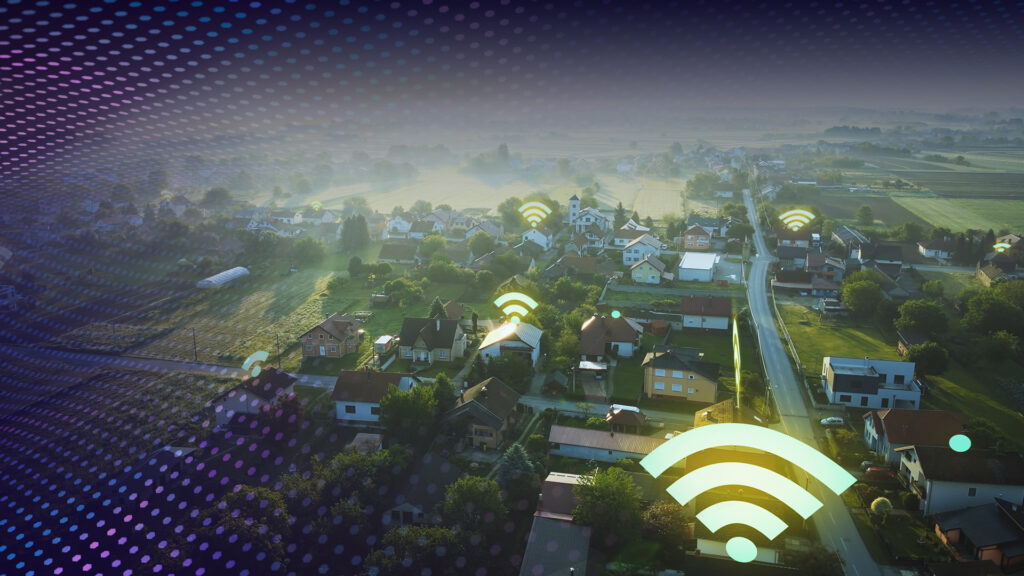 Top down view of a small rural town with digital wi-fi signals above homes and businesses.