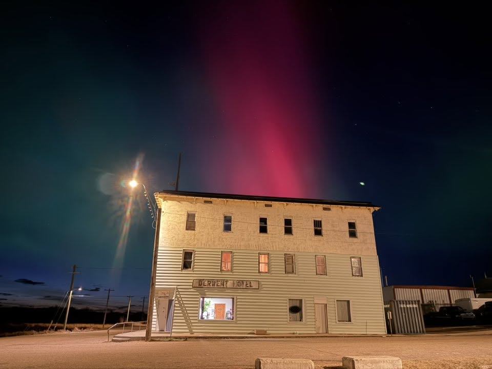 The Derwent Hotel under the northern lights in Derwent, Alberta