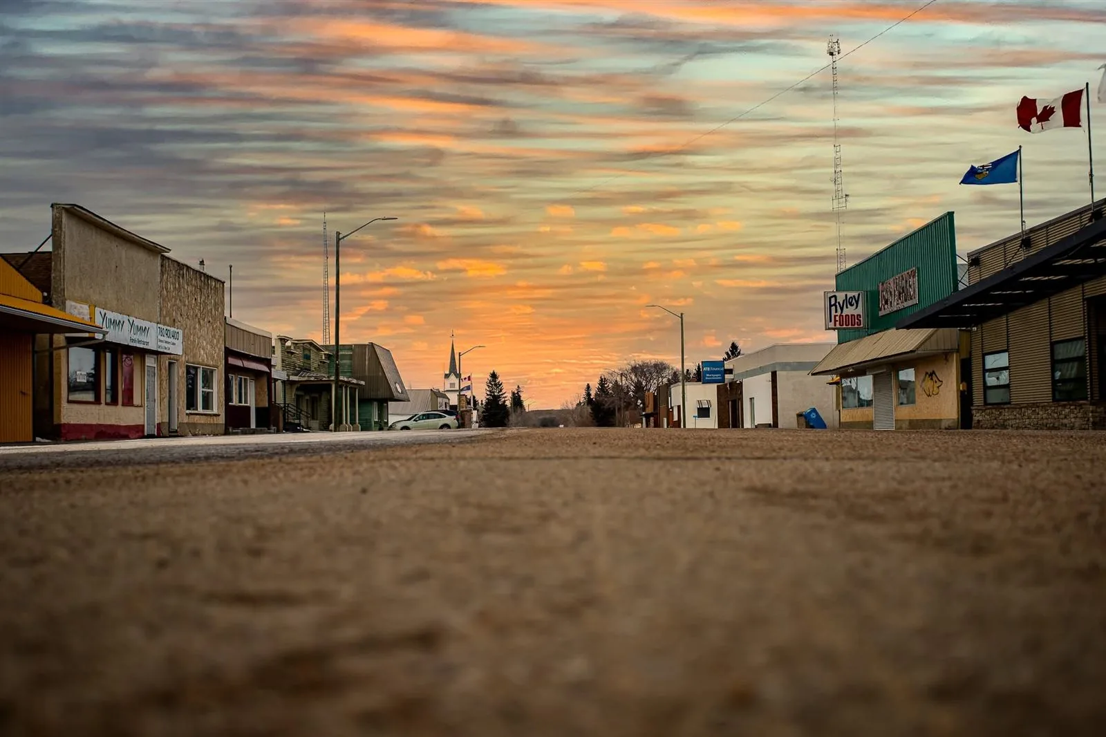 Main street in Ryley, Alberta at sunset, with local shops including Ryley Foods