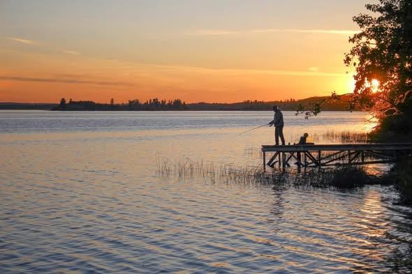 Fishing from a dock at sunset on Thunder Lake, Alberta