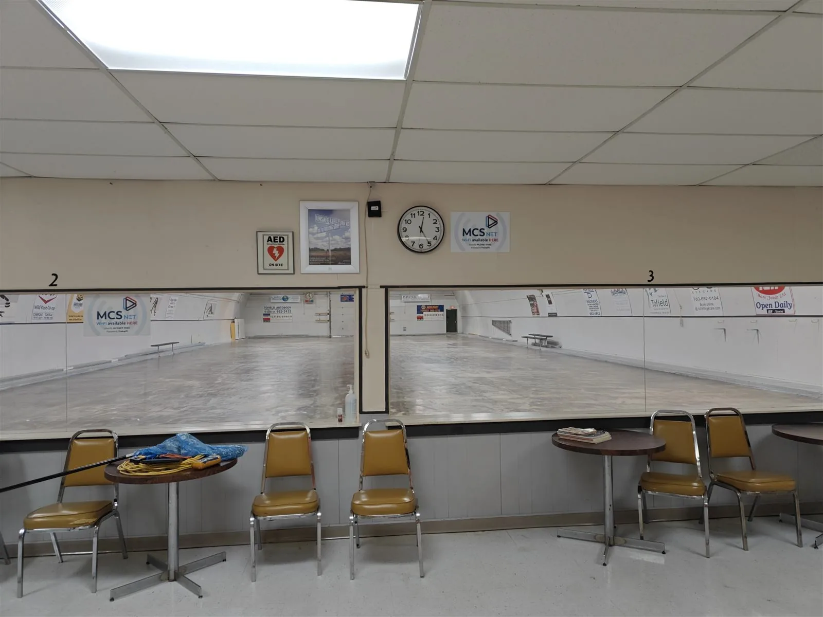 Ice surface at the Tofield Curling Rink with an MCSnet Wi-Fi available sign on the wall