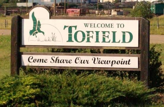 The Welcome to Tofield sign in Tofield, Alberta, a wooden roadside sign with a painted bird and the words Come Share Our Viewpoint