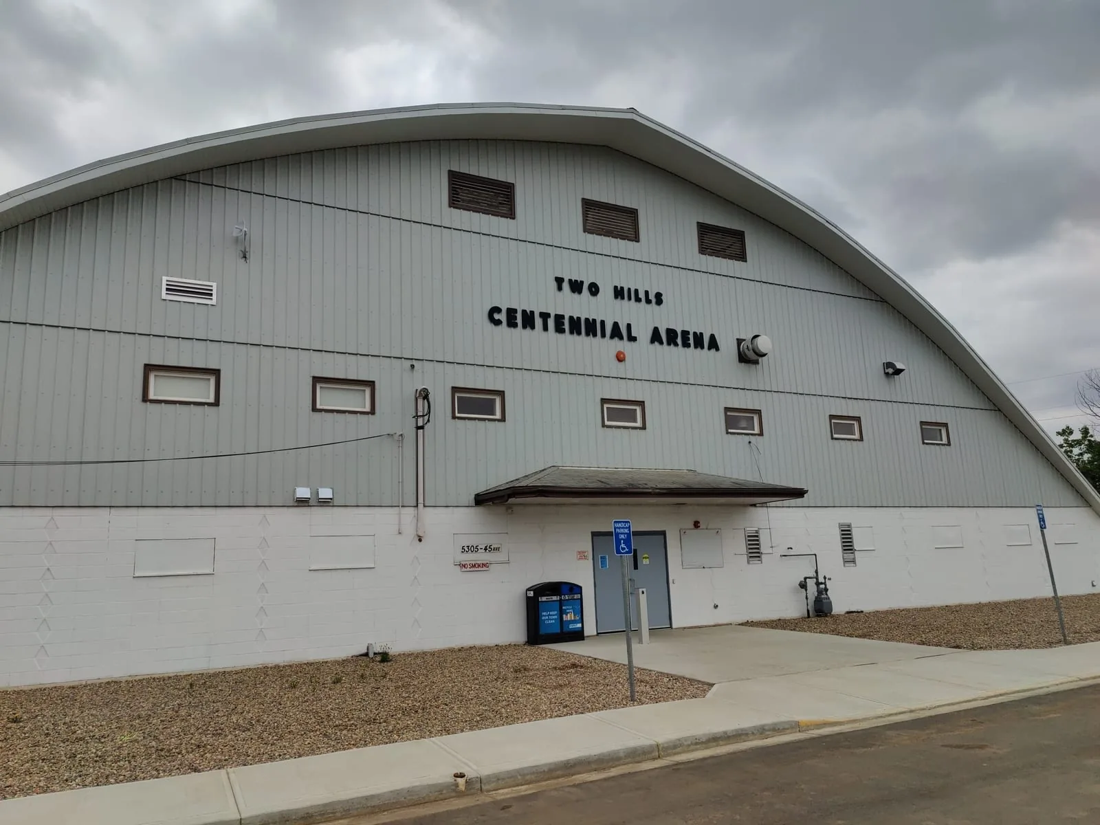 Exterior of the Two Hills Centennial Arena, a curved-roof rink with its address plate reading 5305-45 Ave, in Two Hills, Alberta